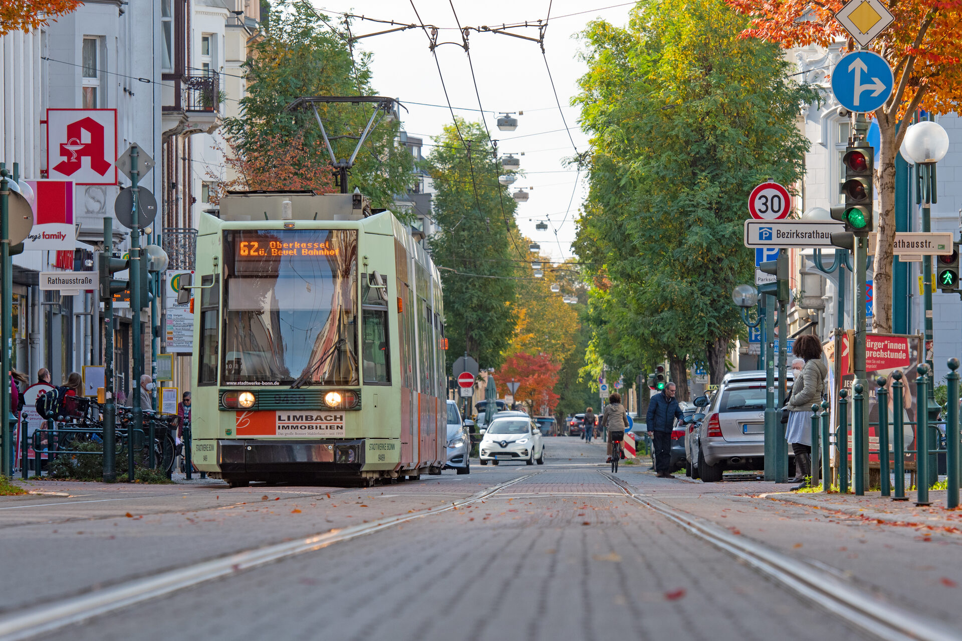 Das Bild zeigt die Friedrich-Breuer-Straße in Beuel im Abschnitt Rathausstraße. Es zeigt den Verkehr der Stadtbahn sowie von Fußgängern, Radfahrern und Autofahrern.