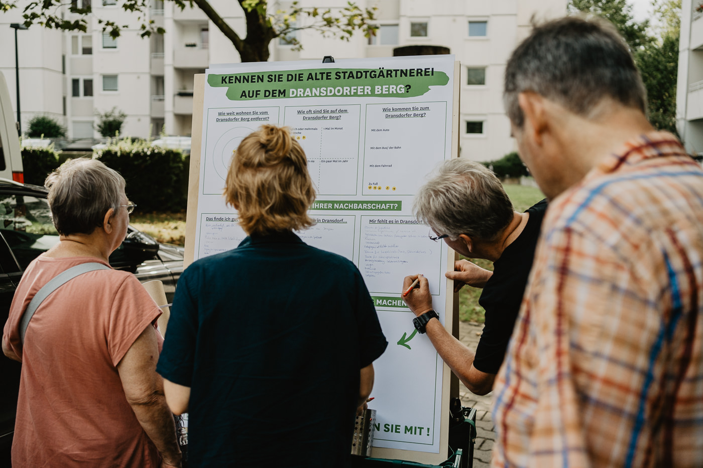 Personen schreiben Anregungen auf ein Plakat