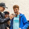 Drei Bonner Jugendliche schauen sich etwas auf einem Smartphone an.